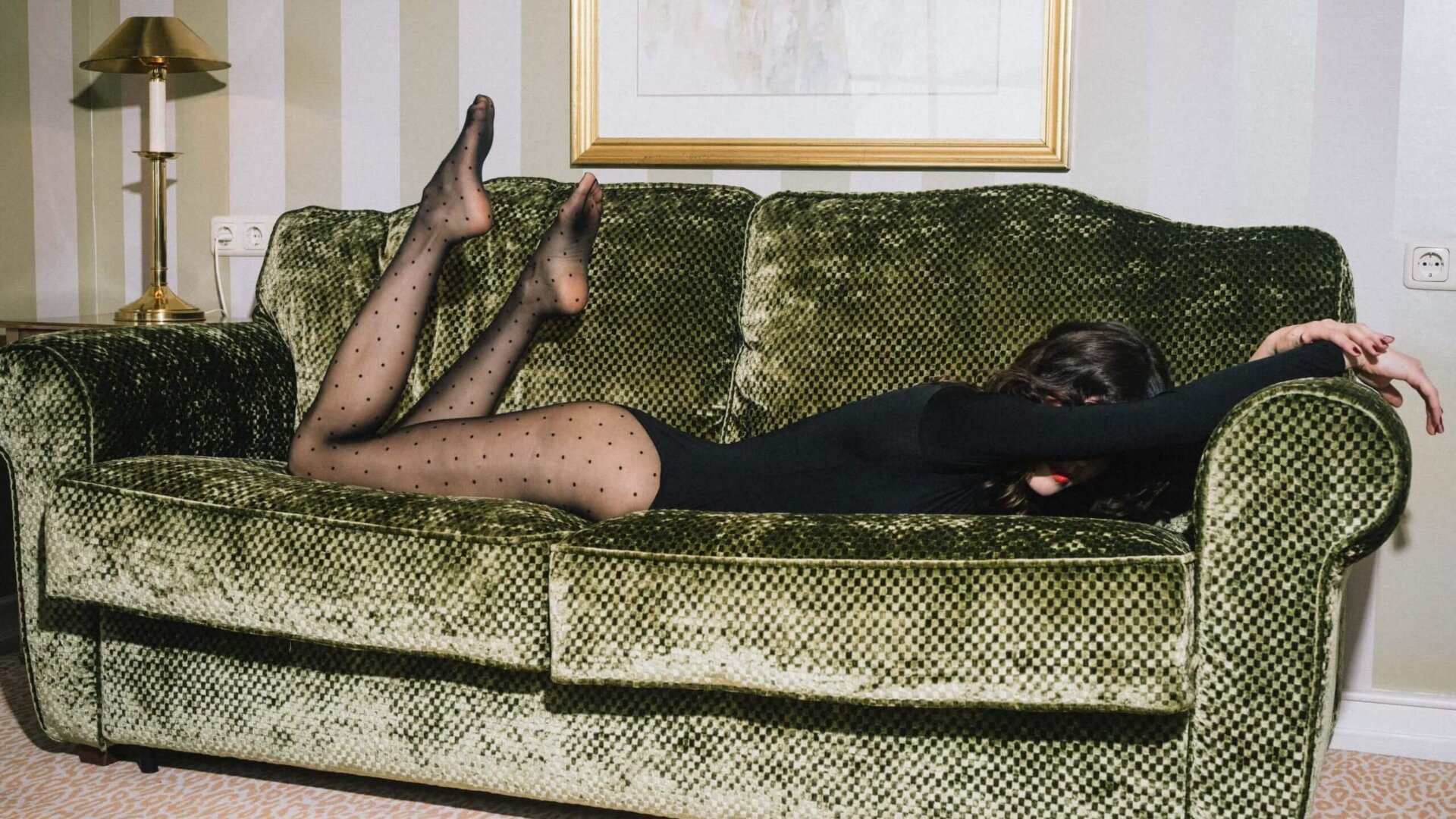 Frau liegt am Sofa