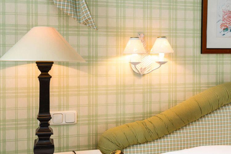 Gemütliches Schlafzimmer im Hotel Edelweiss mit eleganter Einrichtung, Lampen und stilvoller Bettwäsche in Lech/Zürs.