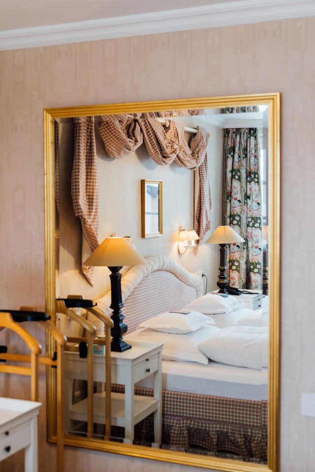 Elegantes Hotelzimmer im Hotel Edelweiss in Lech/Zürs mit stilvollem Spiegel und gemütlicher Einrichtung.