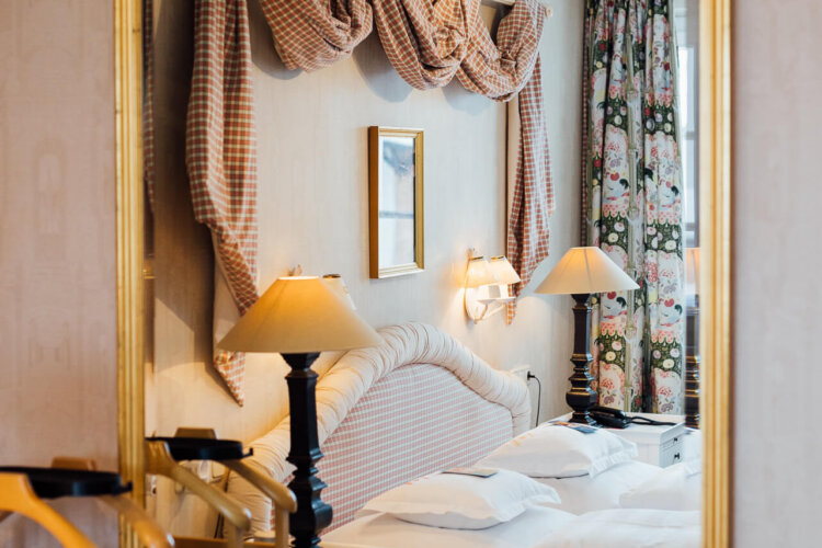 Elegantes Hotelzimmer im Hotel Edelweiss in Lech/Zürs mit stilvollem Spiegel und gemütlicher Einrichtung.