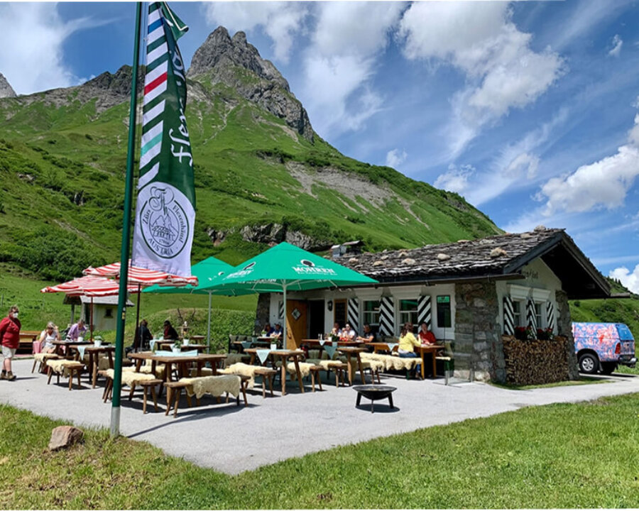 Terrasse des Hotel Edelweiss in Lech/Zürs mit Blick auf die Berge, Gäste genießen die alpine Atmosphäre.