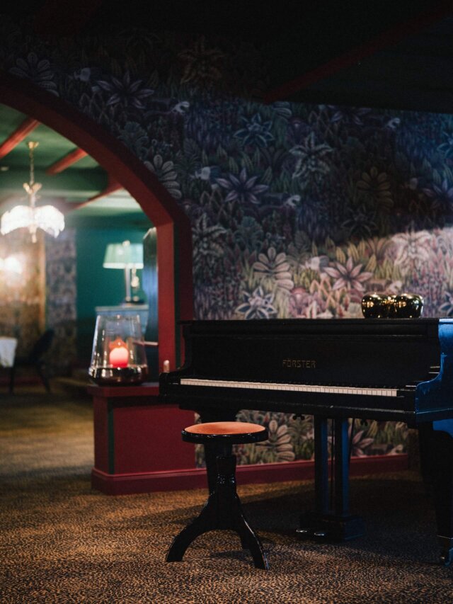 Elegantes Klavier im Hotel Edelweiss, umgeben von stilvollem Ambiente und buntem Wanddesign in Lech/Zürs am Arlberg.