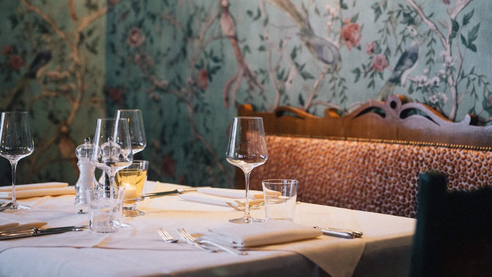 Elegant dekorierter Tisch im Restaurant des Hotels Edelweiss in Lech/Zürs, umgeben von stilvollem Blumentapeten.