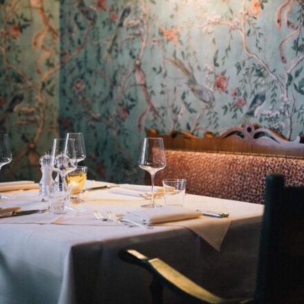 Elegant dekorierter Tisch im Restaurant des Hotels Edelweiss in Lech/Zürs, umgeben von stilvollem Blumentapeten.