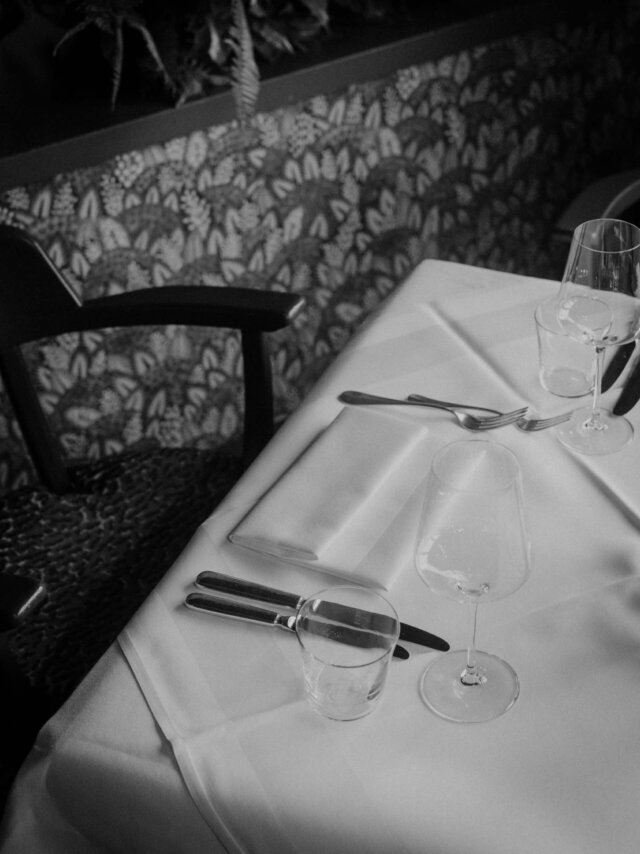 Eleganter Tisch im Restaurant des Hotels Edelweiss in Lech, gedeckt mit Besteck und Gläsern für ein feines Dinner.