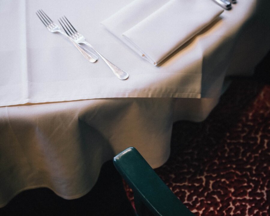 Elegant gedeckter Tisch im Hotel Edelweiss mit Besteck und Tischdecke, perfekte Atmosphäre für genussvolle Mahlzeiten.