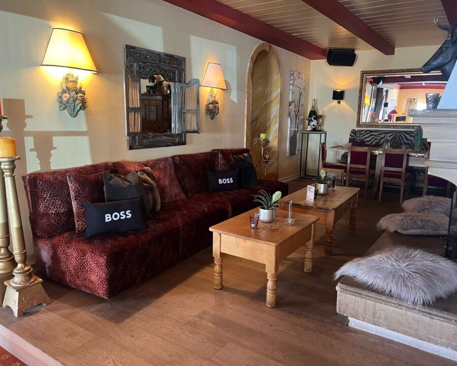 Gemütliche Lounge im Hotel Edelweiss mit stilvollem Sofa, Holz-Elementen und einladenden Beleuchtung. Ideal zum Entspannen.