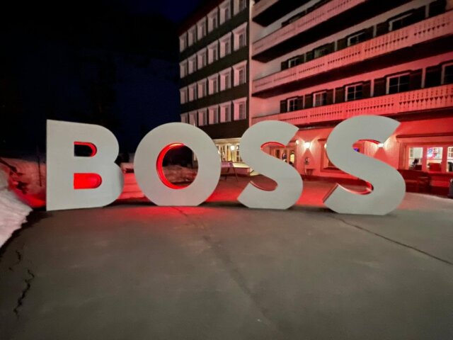 Große, beleuchtete Buchstaben formen das Wort BOSS vor dem Hotel Edelweiss in Lech/Zürs am Arlberg.