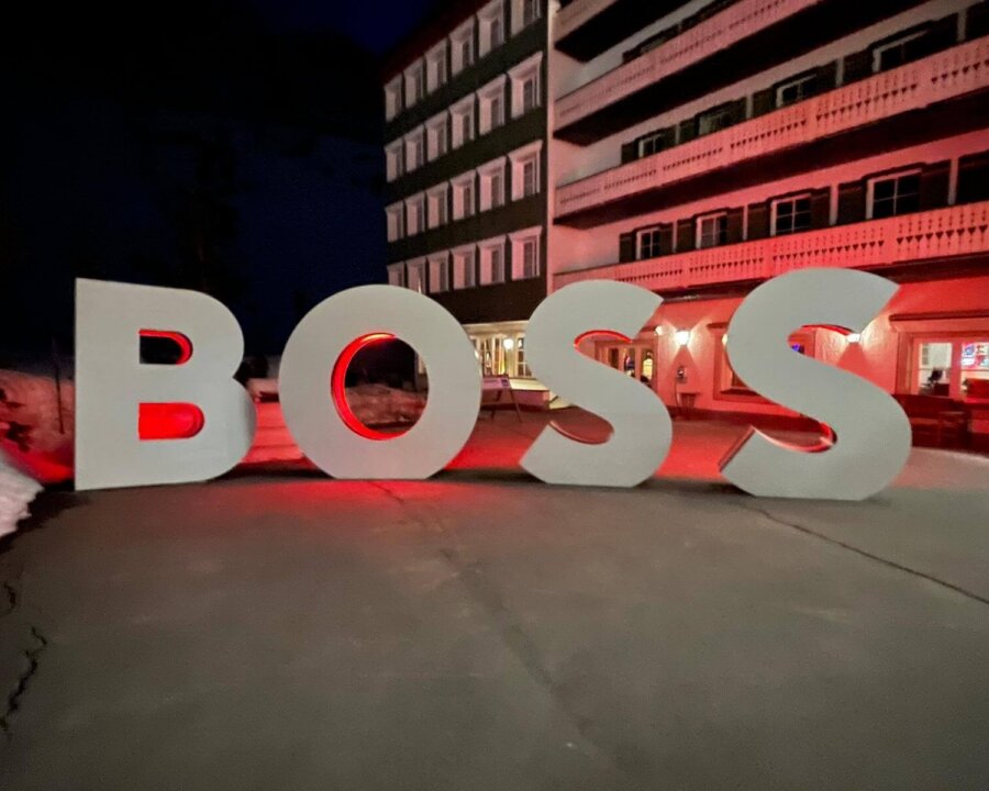 Große, beleuchtete Buchstaben formen das Wort BOSS vor dem Hotel Edelweiss in Lech/Zürs am Arlberg.