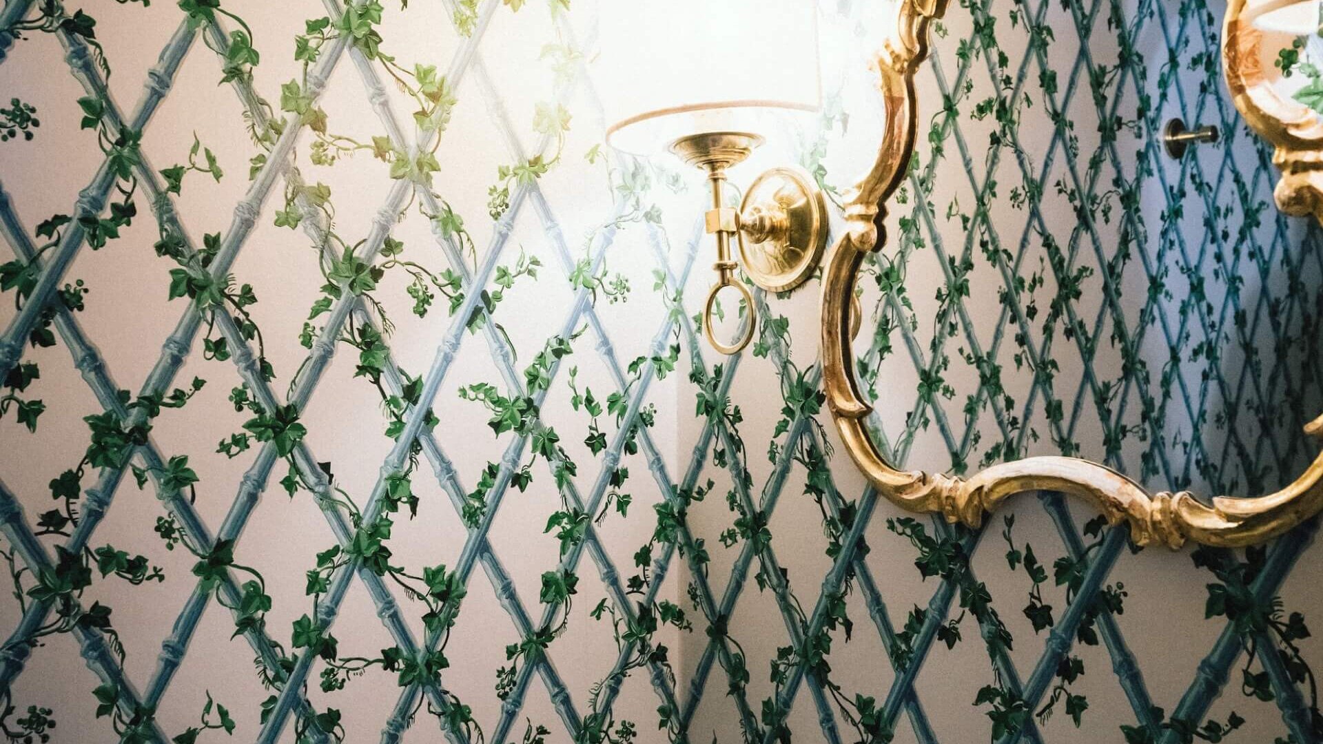 Elegante Badausstattung im Hotel Edelweiss mit floralen Tapeten und klassischem Spiegel, ideal für einen luxuriösen Aufenthalt.