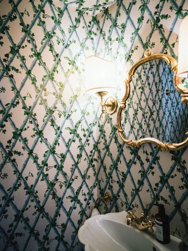 Elegante Badausstattung im Hotel Edelweiss mit floralen Tapeten und klassischem Spiegel, ideal für einen luxuriösen Aufenthalt.