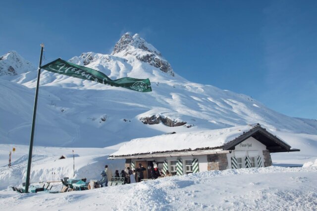 Gemütliche Berghütte im Schnee mit Blick auf die beeindruckenden Alpen, ideal für Erholung in Lech/Zürs am Arlberg.