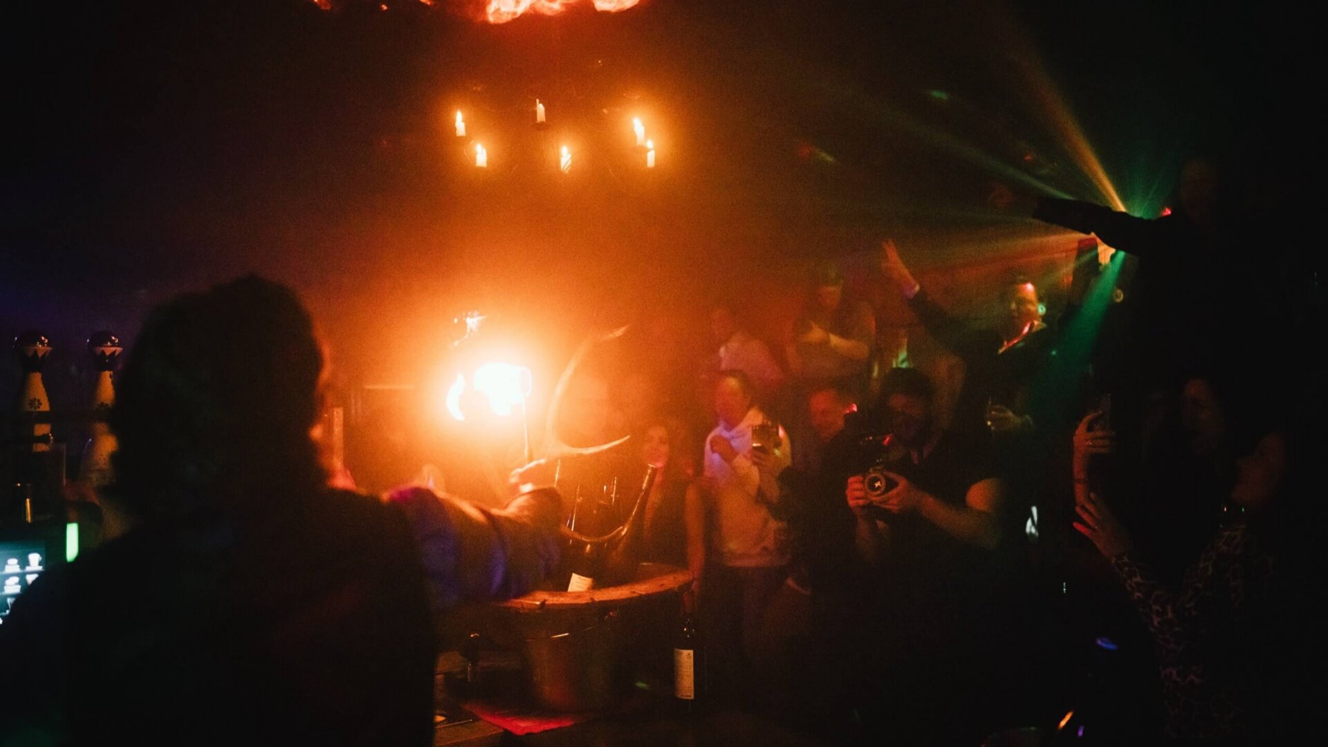 Feiernde Gäste im Hotel Edelweiss bei einer spektakulären Live-Performance mit Lichteffekten und Feuer.