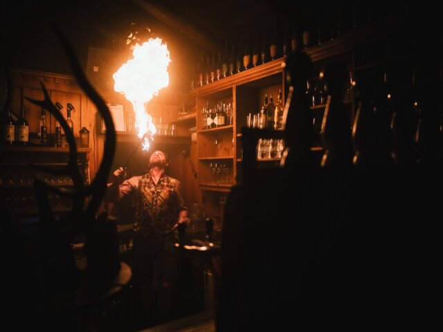 Feuerspucker begeistert Gäste in der Bar des Hotels Edelweiss in Lech/Zürs am Arlberg mit seiner spektakulären Darbietung.