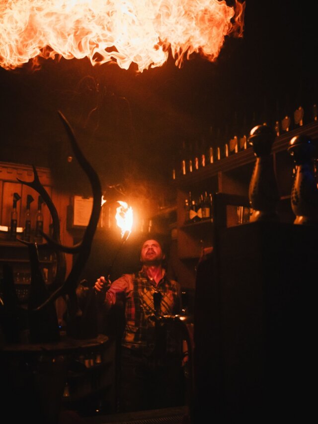 Barkeeper im Hotel Edelweiss zeigt beeindruckende Feuerakrobatik in einer gemütlichen Bar-Atmosphäre.