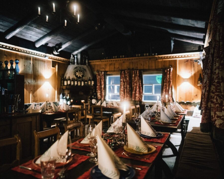 Gemütliches Restaurant im Hotel Edelweiss mit festlich gedeckten Tischen und rustikaler Holzdeko in Lech/Zürs.