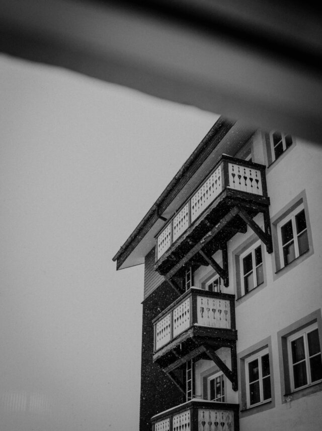 Blick auf den Balkon des Hotel Edelweiss in Lech/Zürs, umgeben von winterlichem Schneefall.
