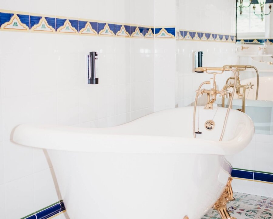 Elegante freistehende Badewanne mit goldenen Füßen im stilvollen Badezimmer des Hotels Edelweiss in Lech/Zürs.