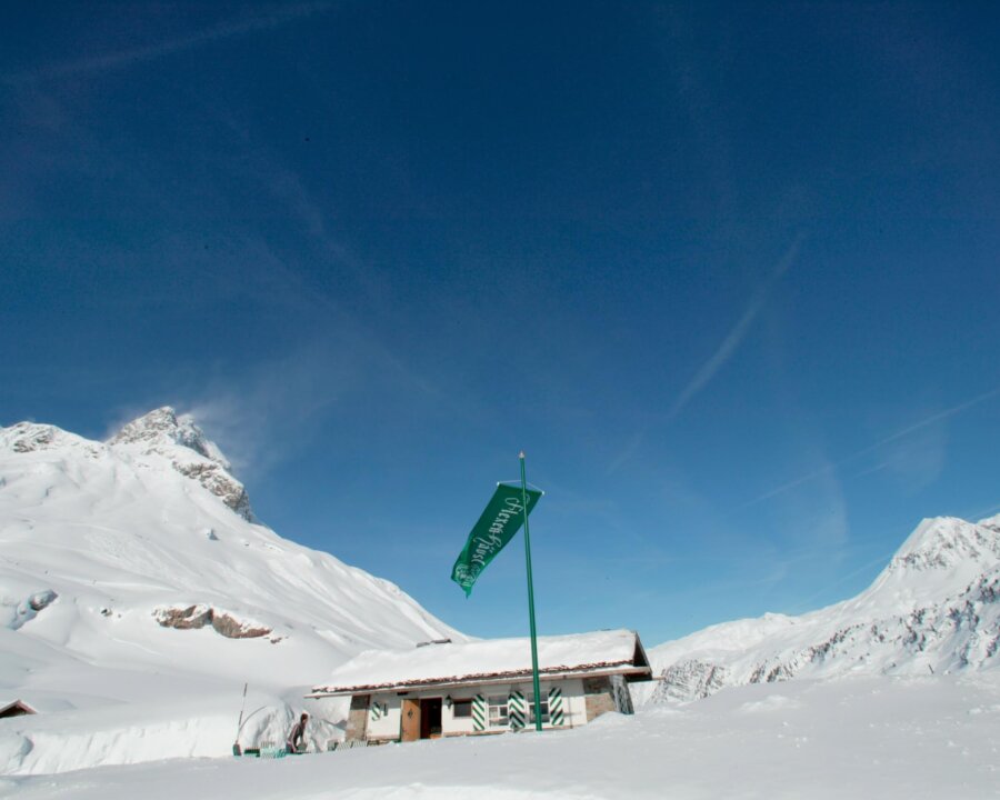 Winterlandschaft mit schneebedecktem Hütten und Brise, ideal für Skiurlaub im Hotel Edelweiss, Lech/Zürs am Arlberg.