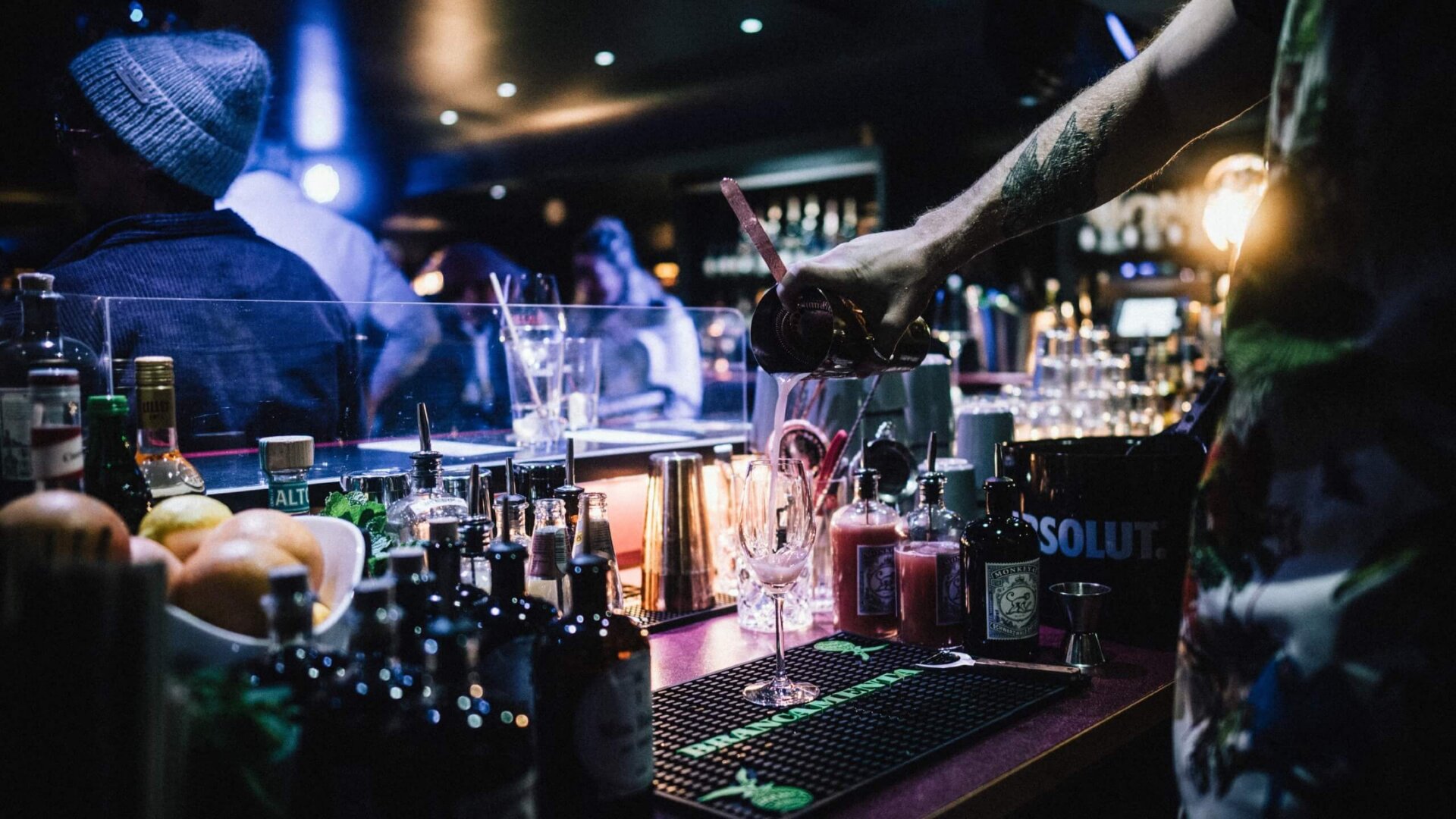 Barkeeper mixt in stilvollem Ambiente einen Cocktail im Hotel Edelweiss in Lech am Arlberg. Beleuchtung sorgt für Atmosphäre.