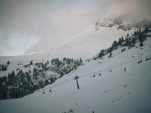 Schneebedeckte Berge und eine Seilbahn in Lech/Zürs am Arlberg für unvergessliche Wintersporterlebnisse.