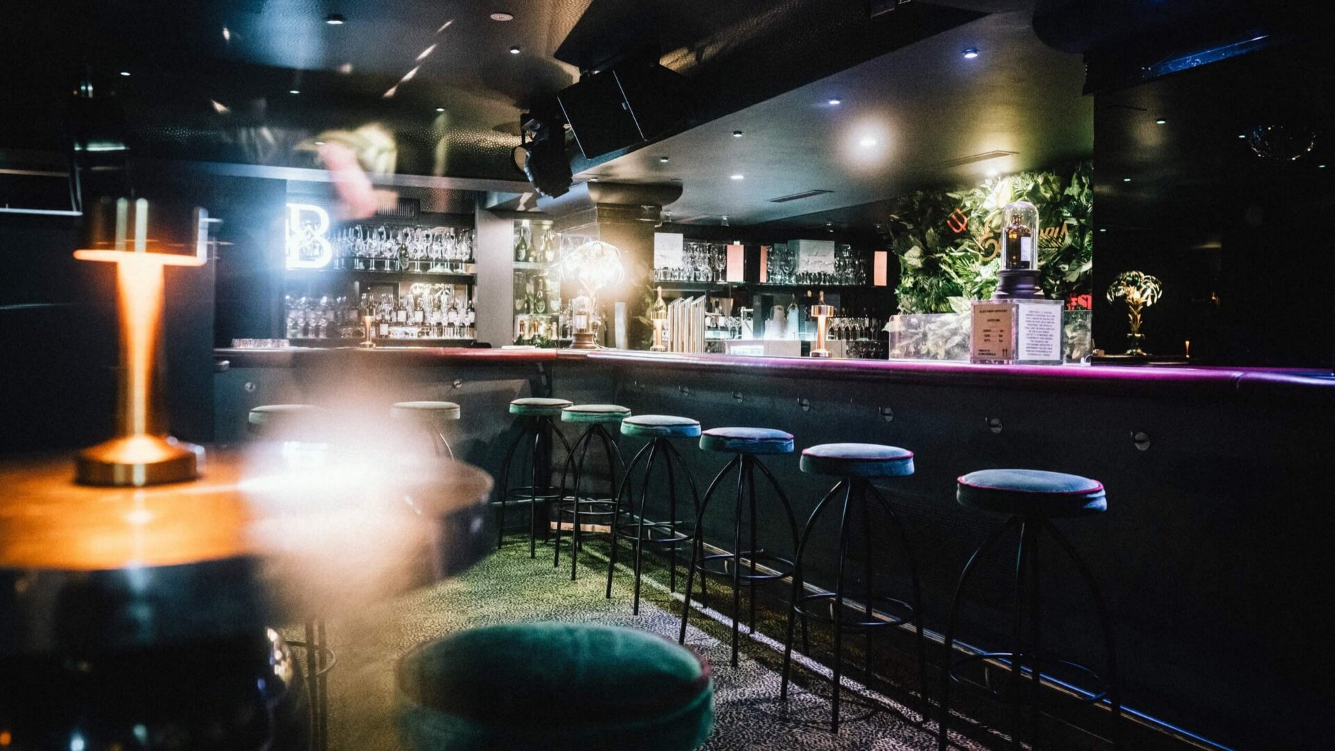 Modern eckiger Barbereich im Hotel Edelweiss mit stilvollen Sitzplätzen und attraktiver Beleuchtung in Lech/Zürs.