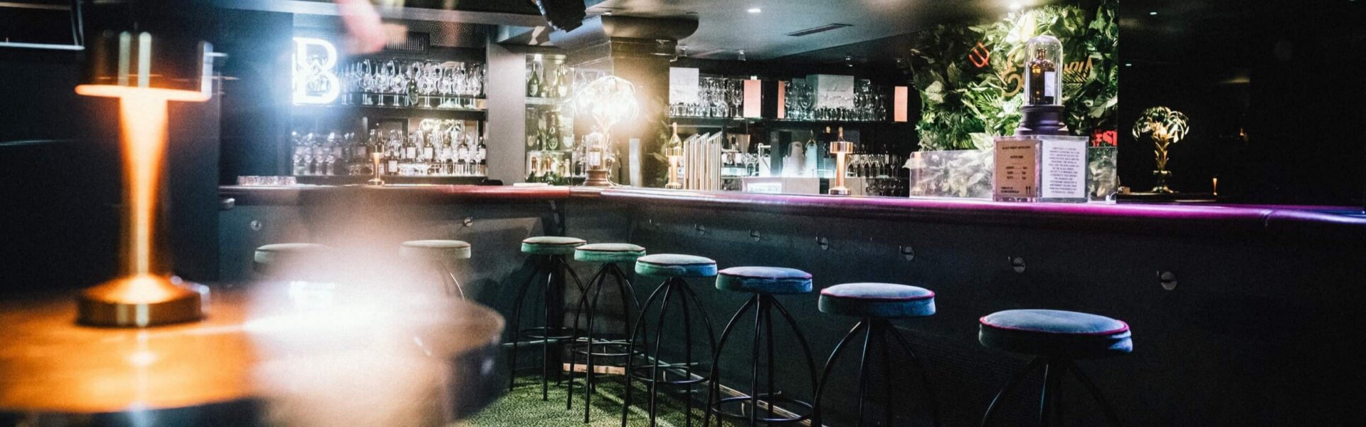 Modern eckiger Barbereich im Hotel Edelweiss mit stilvollen Sitzplätzen und attraktiver Beleuchtung in Lech/Zürs.