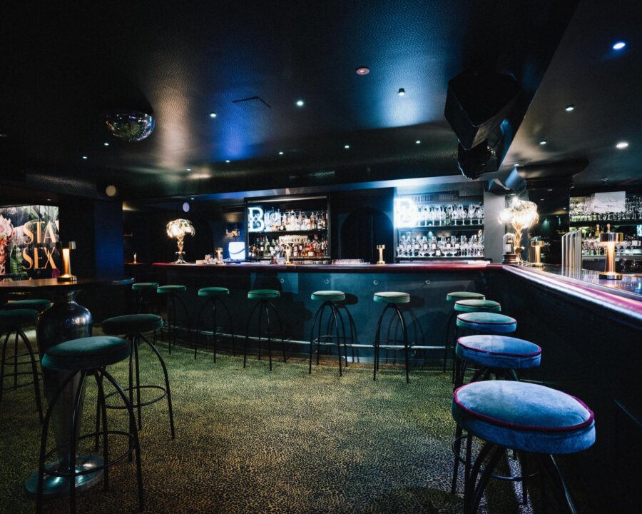 Elegante Bar im Hotel Edelweiss mit stilvollen Sitzgelegenheiten und beleuchtetem Getränkebereich in Lech/Zürs.