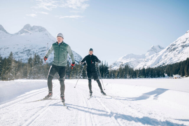 Langläufer genießen die verschneite Landschaft bei einem Langlauf in Lech/Zürs am Arlberg. Ideal für Winterurlaub.