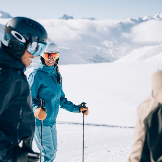 Freundliche Skifahrer genießen den Schnee in Lech/Zürs am Arlberg, umgeben von majestätischer Berglandschaft.
