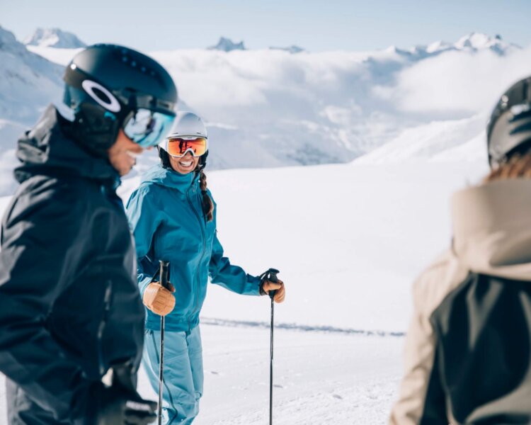 Freundliche Skifahrer genießen den Schnee in Lech/Zürs am Arlberg, umgeben von majestätischer Berglandschaft.