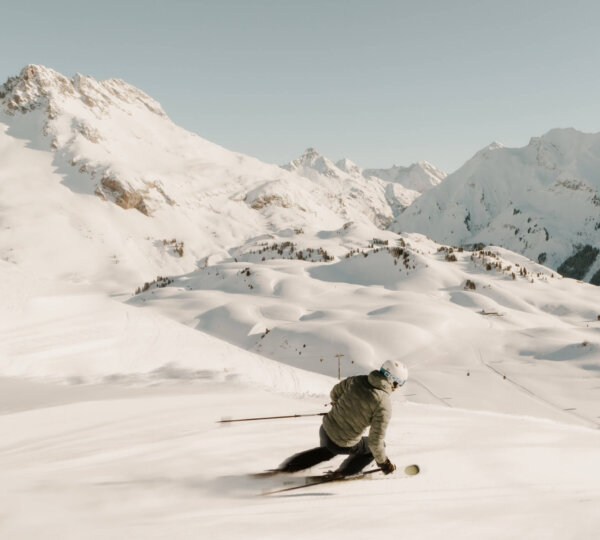 Skifahrer genießt die Pulverschneepisten in den Alpen rund um das Hotel Edelweiss in Lech/Zürs am Arlberg.