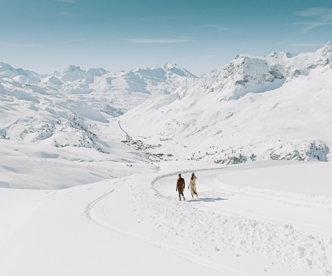 Paar genießt winterliche Wanderung durch die verschneite Landschaft von Lech/Zürs am Arlberg.