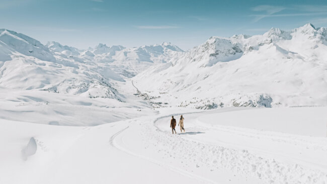 Paar genießt winterliche Wanderung durch die verschneite Landschaft von Lech/Zürs am Arlberg.