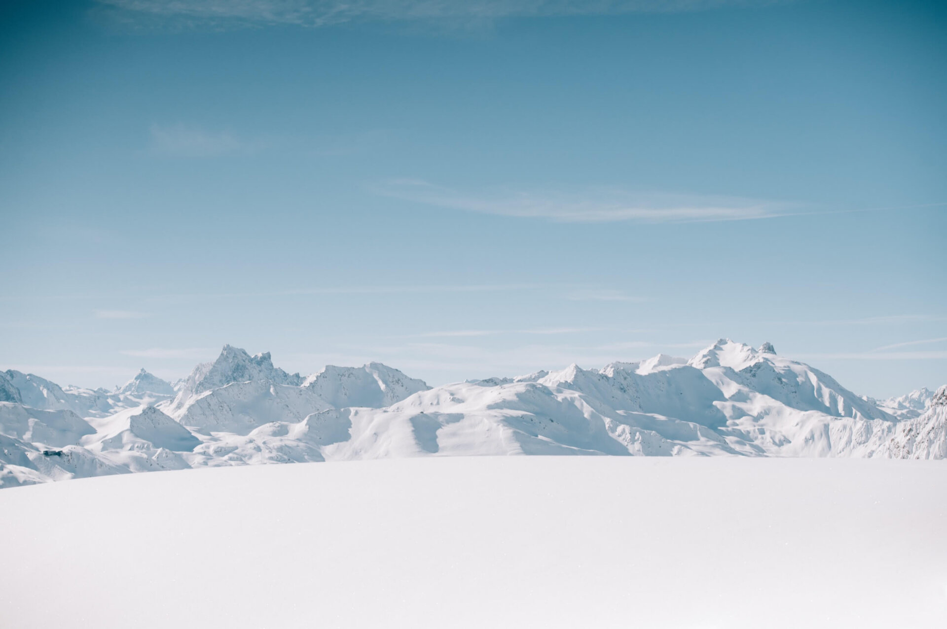 Panorama der schneebedeckten Berge in Lech/Zürs, ideal für Winterurlaub und Skiabenteuer im Hotel Edelweiss.