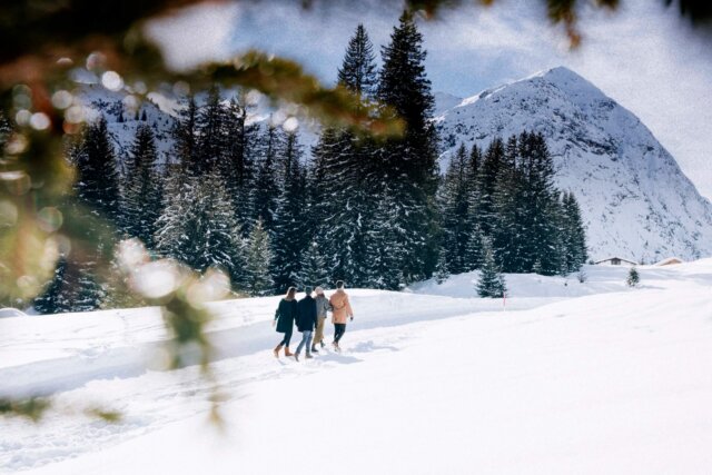 Winterliche Wanderung in Lech/Zürs; Freunde genießen die verschneite Landschaft und die Bergkulisse des Arlbergs.