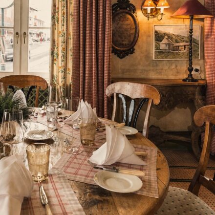 Gemütlicher Speisesaal im Hotel Edelweiss mit attraktiv gedecktem Tisch und traditioneller Alpineinrichtung.
