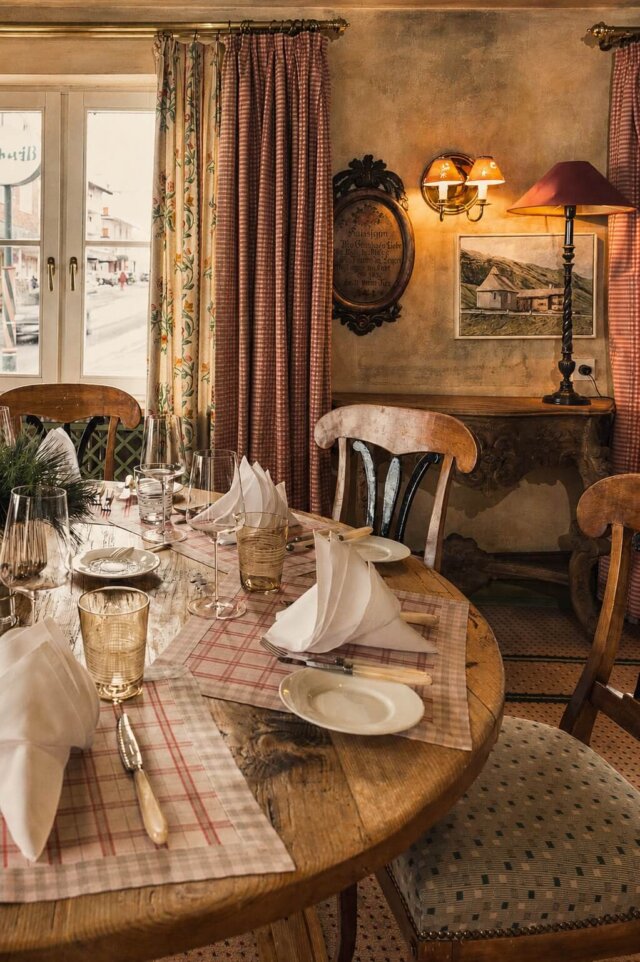 Gemütlicher Speisesaal im Hotel Edelweiss mit attraktiv gedecktem Tisch und traditioneller Alpineinrichtung.