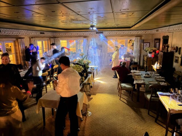 Geselliges Abendessen im Hotel Edelweiss, Lech/Zürs: Gäste genießen das Zusammensein in stilvollem Ambiente.