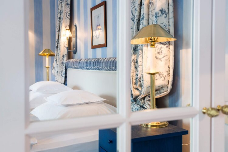 Elegantes Schlafzimmer im Hotel Edelweiss, Lech/Zürs mit stilvollen Vorhängen und entspannender Atmosphäre.