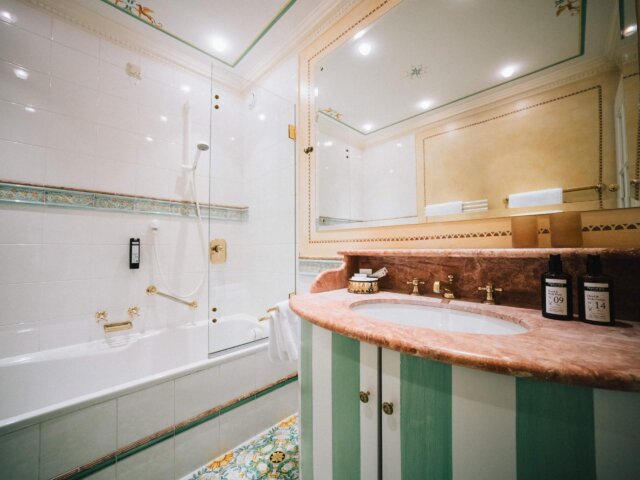 Elegantes Badezimmer im Hotel Edelweiss mit Badewanne, Dusche und hochwertigen Pflegeprodukten in Lech/Zürs.