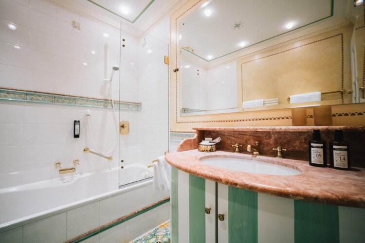 Elegantes Badezimmer im Hotel Edelweiss mit Badewanne, Dusche und hochwertigen Pflegeprodukten in Lech/Zürs.