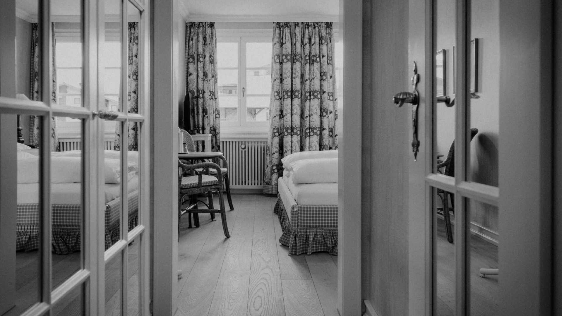 Blick auf ein stilvolles Hotelzimmer im Hotel Edelweiss, Lech/Zürs, mit einladendem Interieur und natürlichem Licht.