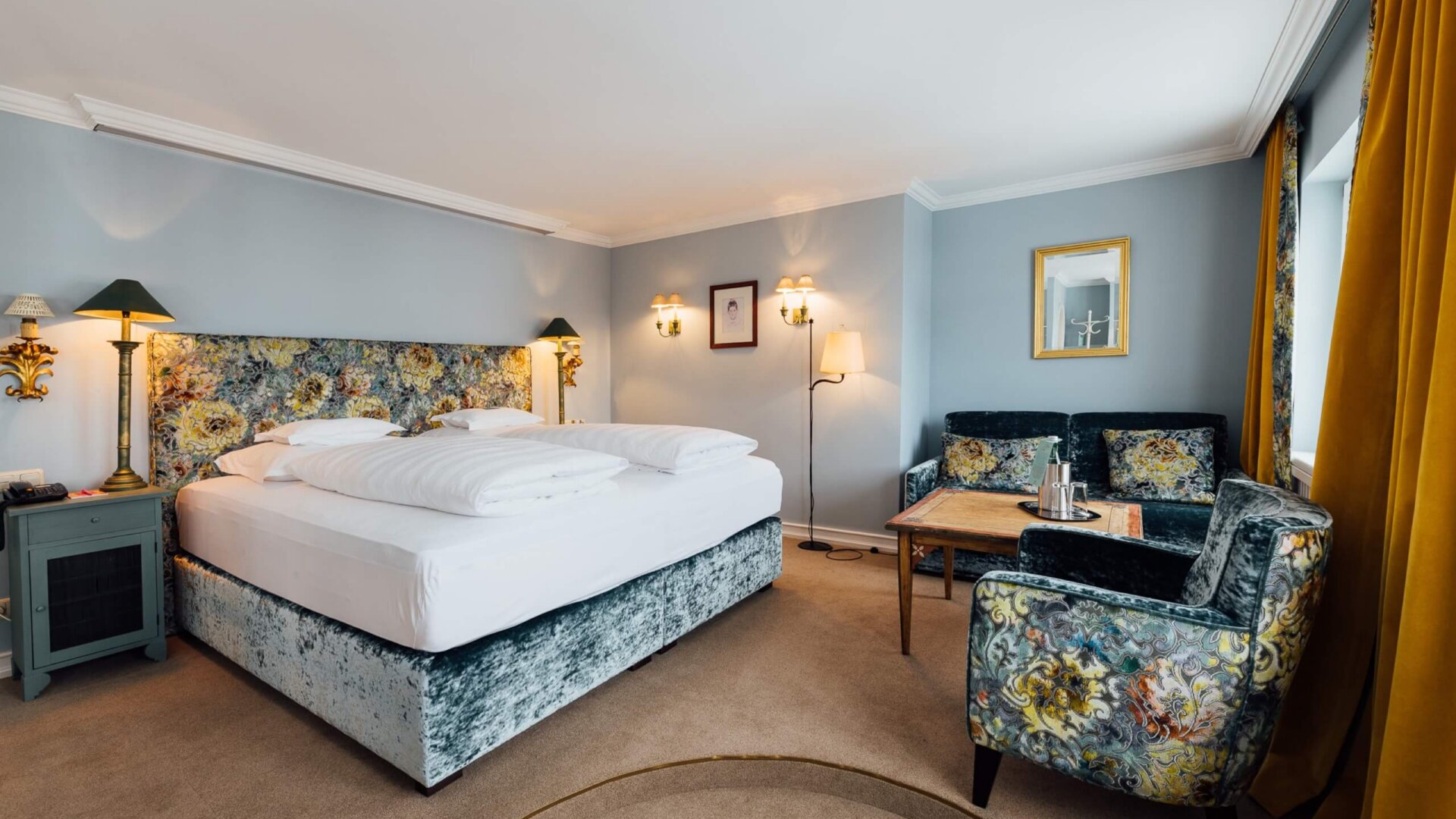 Geräumiges Hotelzimmer im Hotel Edelweiss in Lech/Zürs mit elegantem Interieur und gemütlicher Sitzecke.