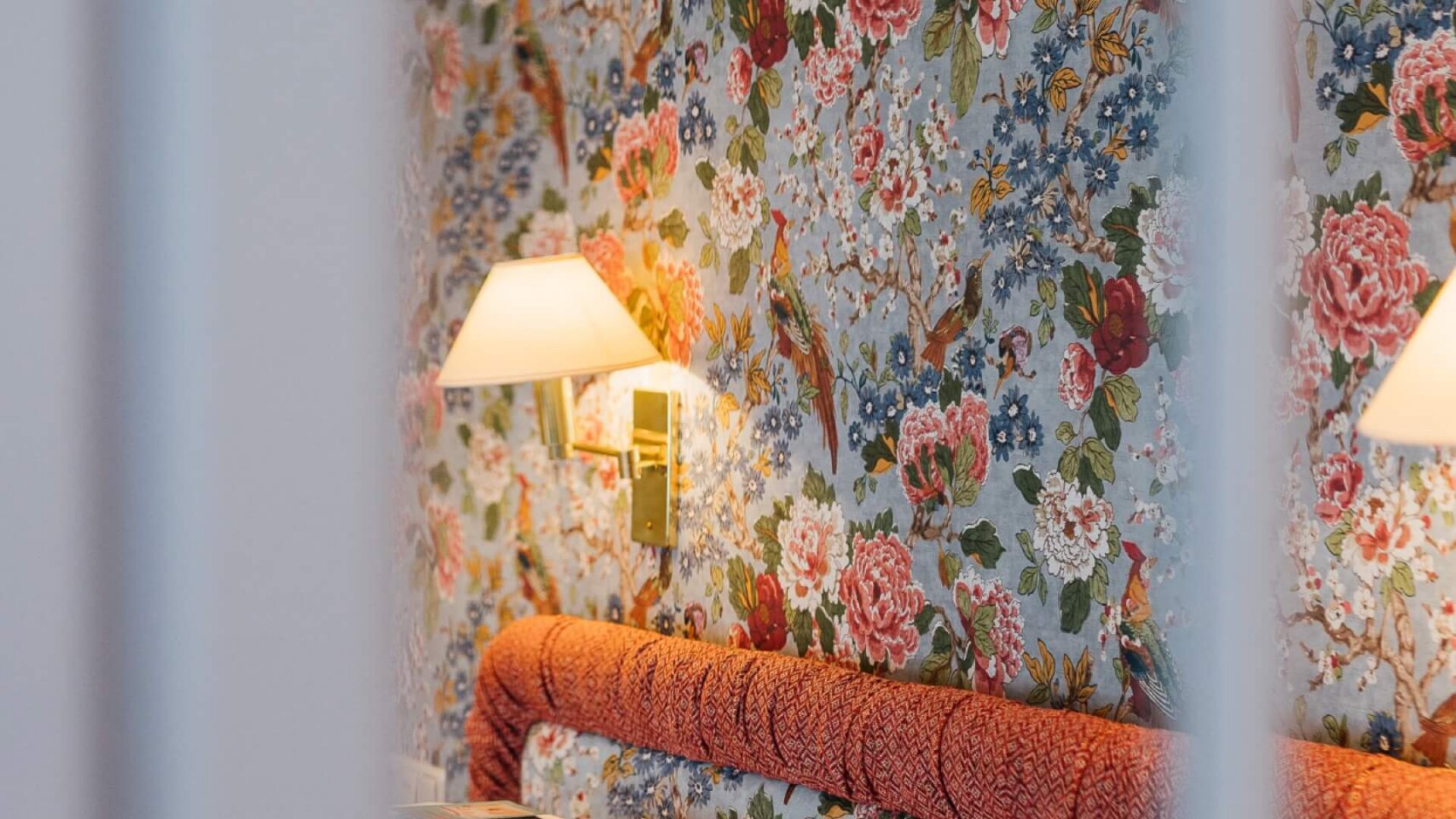 Elegantes Hotelzimmer im Hotel Edelweiss mit floralem Muster und stimmungsvollem Licht in Lech/Zürs am Arlberg.