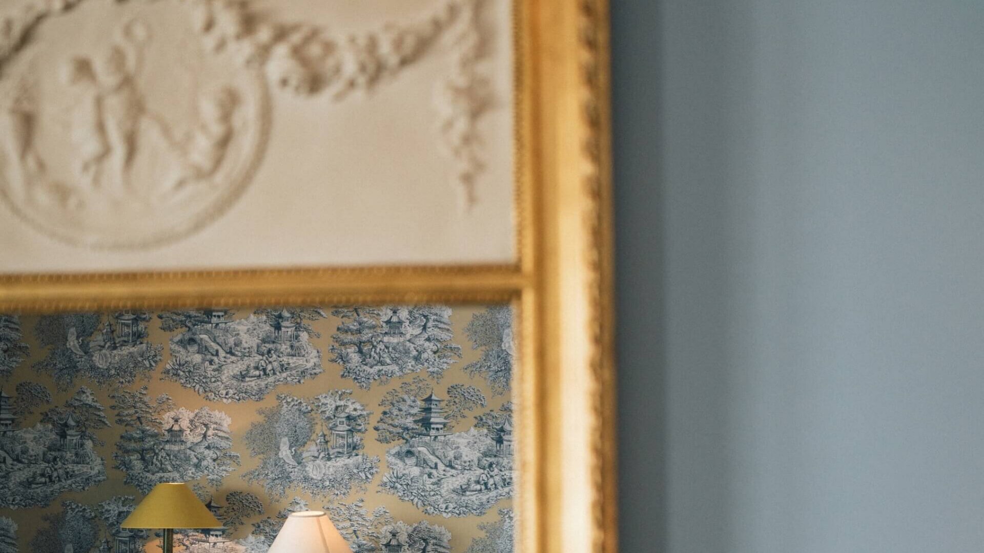 Elegantes Hotelzimmer im Hotel Edelweiss, gespiegelt im goldenen Rahmen, mit stilvollem Wallpaper und gemütlicher Beleuchtung.