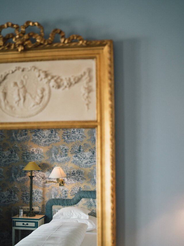 Elegantes Hotelzimmer im Hotel Edelweiss, gespiegelt im goldenen Rahmen, mit stilvollem Wallpaper und gemütlicher Beleuchtung.