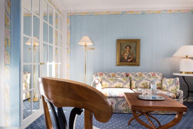 Elegantes Hotelzimmer im Hotel Edelweiss mit Kunstwerk, gemütlichem Sofa und stilvollem Interieur in Lech/Zürs.