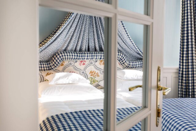 Gemütliches Doppelzimmer im Hotel Edelweiss mit eleganter Bettwäsche und stilvollen Vorhängen in Lech/Zürs.