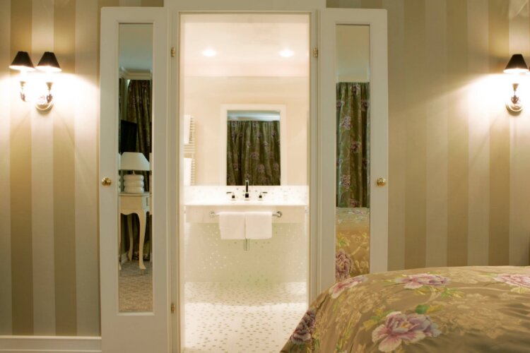Elegant eingerichtetes Hotelzimmer im Hotel Edelweiss, Lech/Zürs, mit Blick auf das moderne Badezimmer.